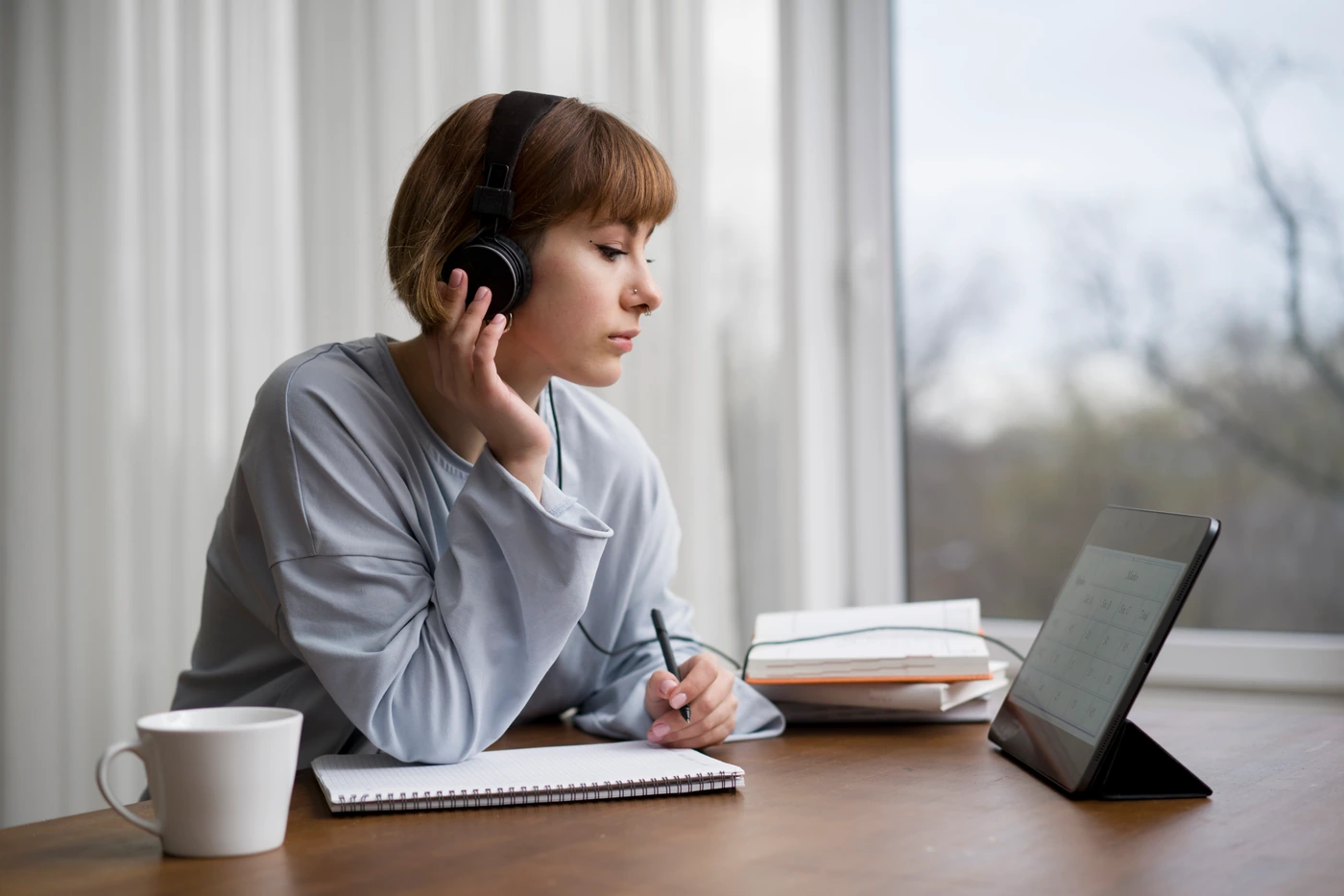 Mujer estudiando con auriculares